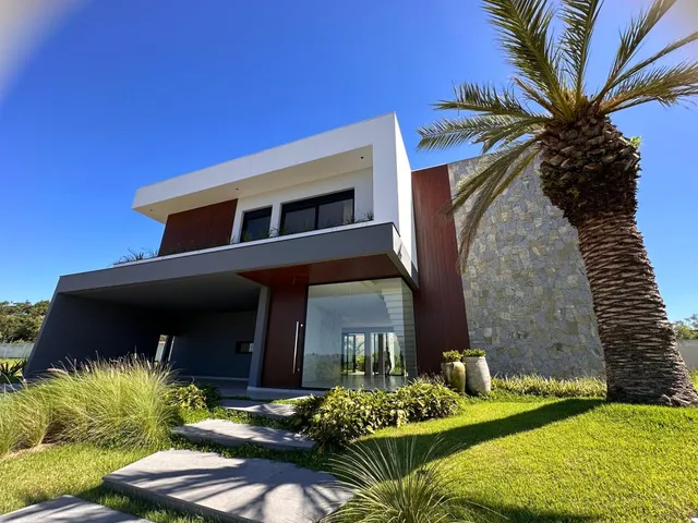 Fachada moderna de uma residência em Lajeado, Brasil, com paisagismo e palmeira.