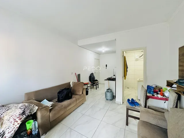 Sala de estar com sofá e piso de cerâmica clara.