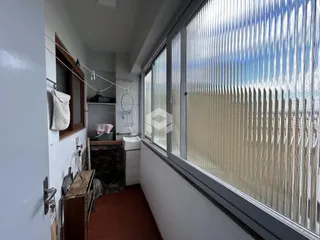Vista interna de um corredor com janela e revestimento de piso de terracota.