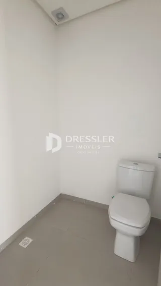A foto mostra o interior de um banheiro com vaso sanitário branco.