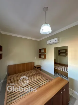 Quarto com cabeceira de madeira e armário de madeira.