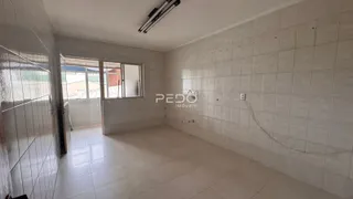 Corredor interno com paredes revestidas de azulejo branco.