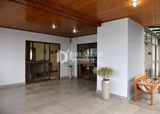 Interior de uma sala com teto de madeira e portas de vidro.