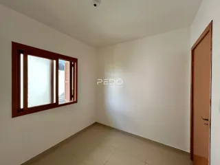 Interior de um cômodo com paredes brancas e piso de cerâmica.