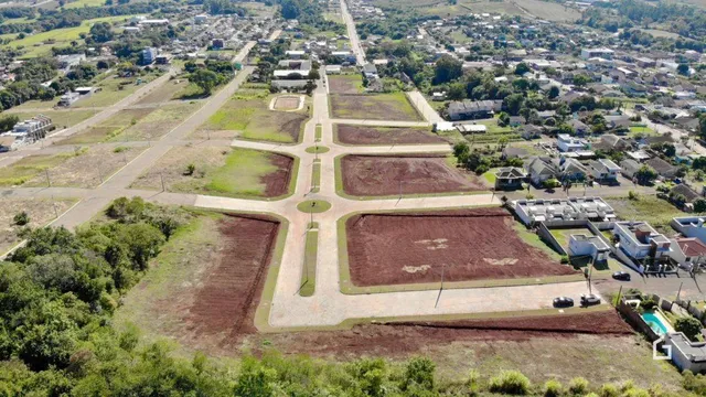 Vista aérea de um terreno aberto com áreas de vegetação e terra arada.