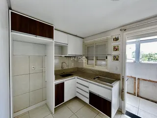 Foto de uma cozinha com armários brancos e bancada de granito.