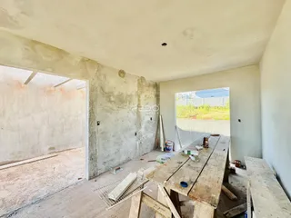 Interior de uma área em construção com paredes de concreto aparente.