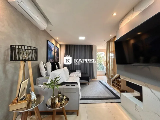 Foto da sala de estar com sofá e televisão em um apartamento.