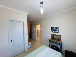 Interior de um quarto com paredes brancas e piso de madeira clara.