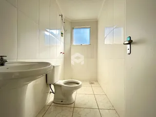 Foto de um banheiro com revestimento cerâmico branco.