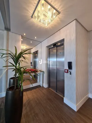 Hall de entrada com piso de madeira e porta de vidro.