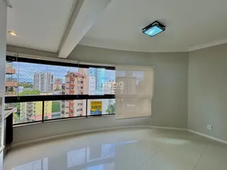 A sala de estar possui piso claro e grandes janelas com vista para a paisagem urbana.