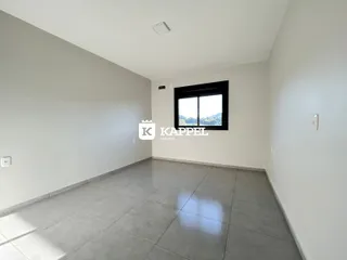 Uma sala ampla com piso de cerâmica e janela.