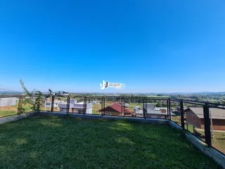 Vista externa da propriedade com gramado e cerca.