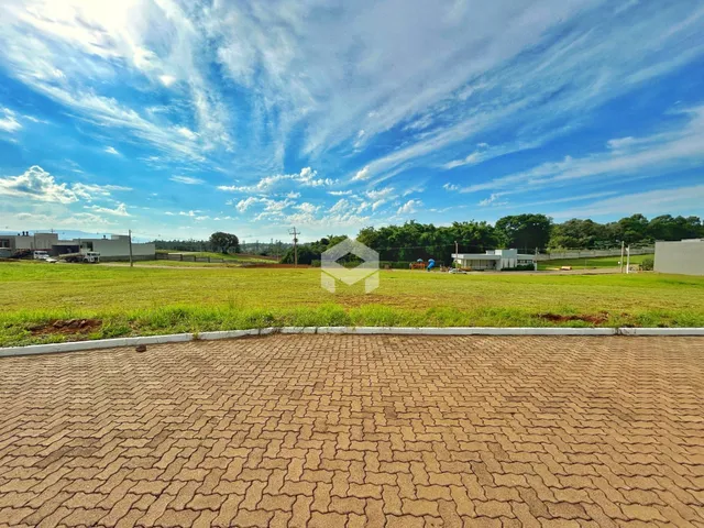 Vista externa de um terreno gramado com paisagem ao fundo.