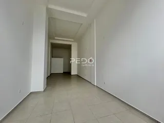 Corredor interno de um imóvel com paredes brancas e piso claro.