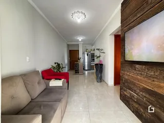 Hall de entrada com sofá e parede de madeira.