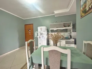 Foto da sala de jantar e cozinha de uma residência.