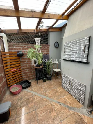 Espaço interno com teto de madeira e parede de tijolos aparentes.