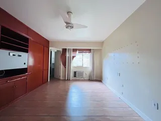 A sala de estar apresenta piso de madeira e armários de madeira na área residencial.