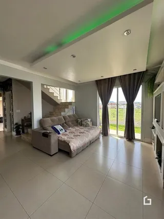 Sala de estar com piso de cerâmica e grandes portas de vidro.