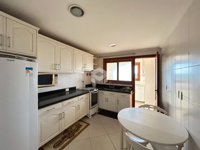 Vista interna de uma cozinha com armários brancos e piso cerâmico.