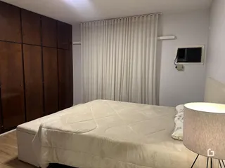 Quarto com armário de madeira e cama grande.