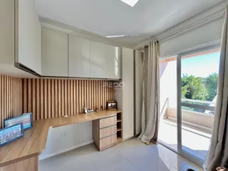 Sala de estar com painel de madeira e porta de vidro que dá para o exterior.