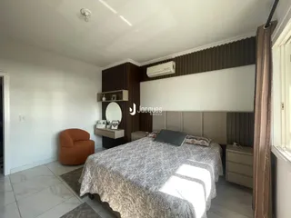 Quarto com cama e decoração de parede em ambiente residencial.