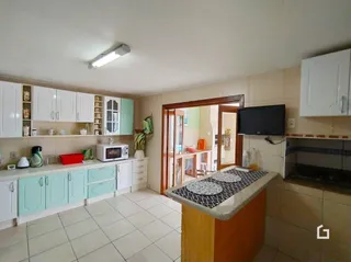 Foto de uma cozinha com armários brancos e piso cerâmico.