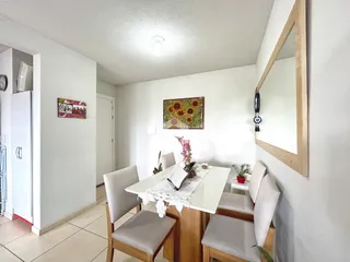 Uma sala de jantar clara com mesa e cadeiras em um imóvel no Brasil.