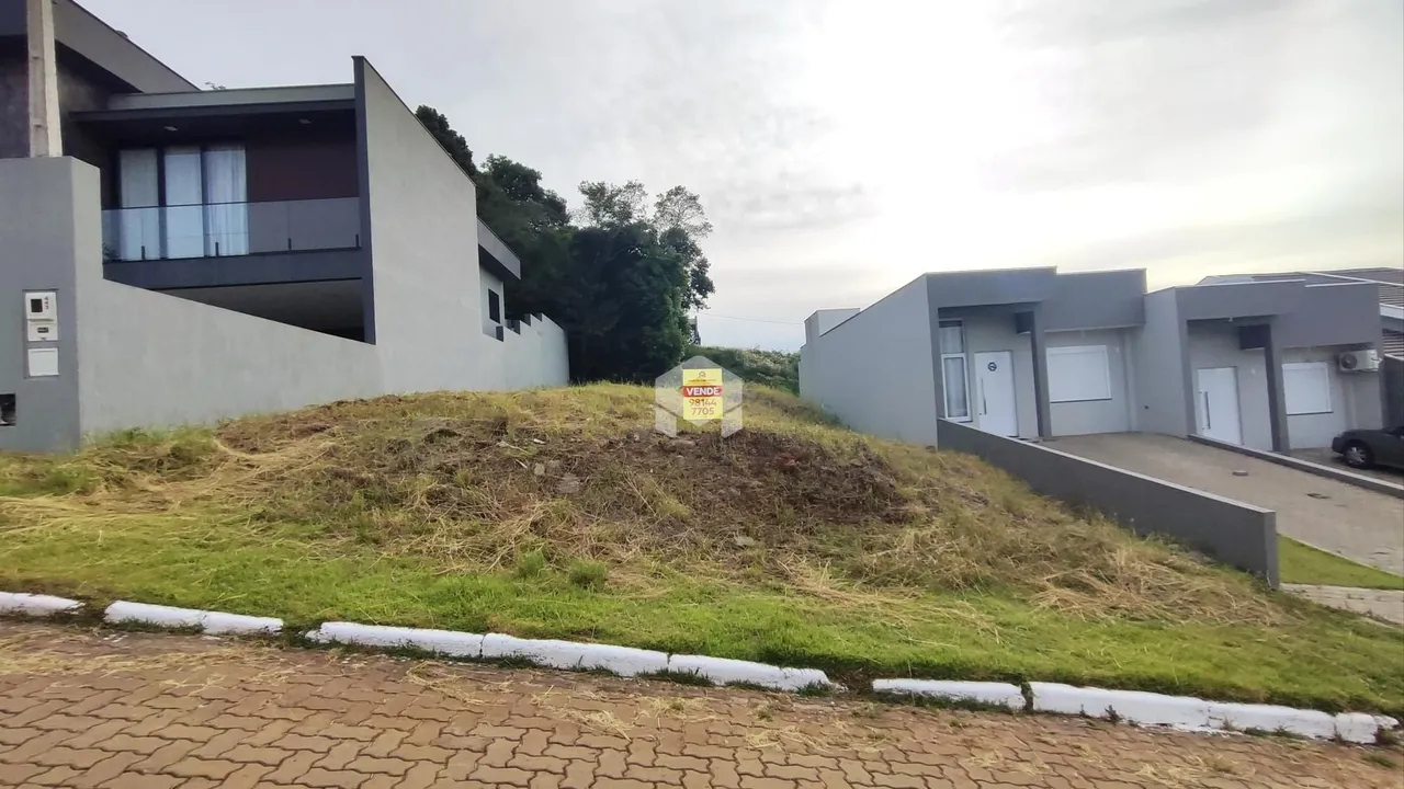 Fachada de uma casa moderna em Lajeado, Brasil, com terreno gramado em primeiro plano.