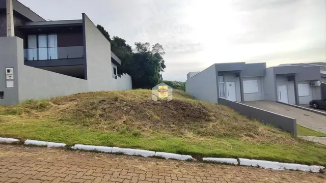 Fachada de uma casa moderna em Lajeado, Brasil, com terreno gramado em primeiro plano.