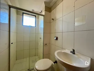 Foto de um banheiro com box de vidro e revestimento cerâmico.