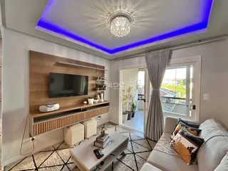 Sala de estar moderna com parede de TV e janela em um apartamento.