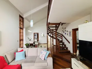 Sala de estar com piso de madeira e escadaria de madeira em um imóvel em Lajeado.