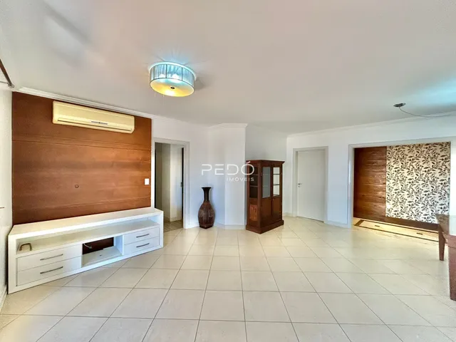 Ambiente interno de uma sala de estar com piso de cerâmica clara e painel de madeira.