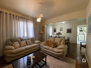 Sala de estar com dois sofás e cortinas claras.