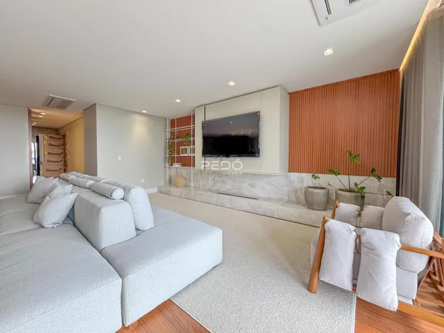 Sala de estar moderna com sofá e decoração clara.