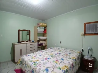 Quarto com cama e armário em uma sala de estar.