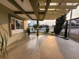 Área externa coberta com piso de cerâmica e vista para o quintal.