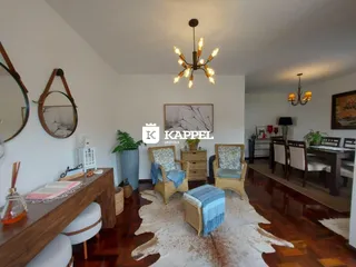 Sala de estar com piso de madeira e móveis de vime.