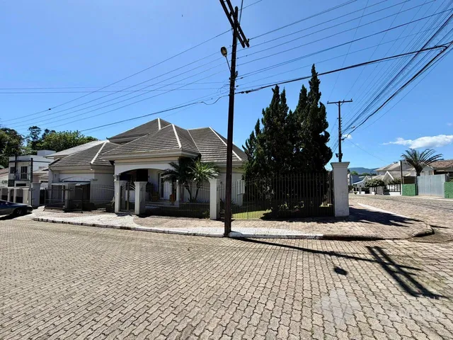 Fachada de uma residência em Lajeado, Brasil, com cerca e portão de ferro.