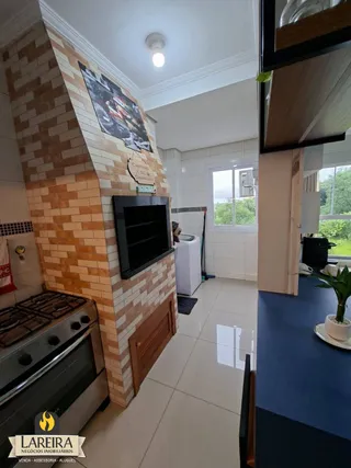 Interior de uma sala com parede de tijolos expostos e piso de cerâmica.