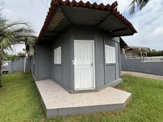 Fachada de uma casa em Lajeado, Brasil, com revestimento cinza e telhado de telhas.