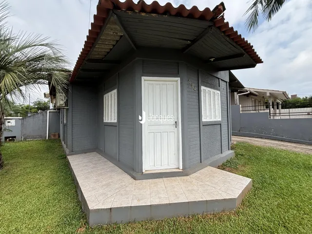 Fachada de uma casa em Lajeado, Brasil, com revestimento cinza e telhado de telhas.