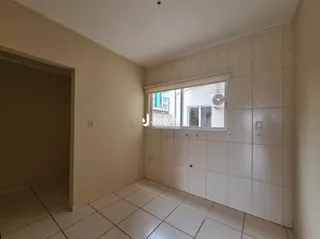 Vista interna de um corredor com piso de cerâmica e janela.