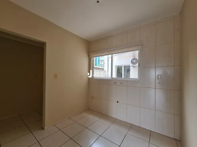 Vista interna de um corredor com piso de cerâmica e janela.