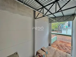 Foto de uma área de construção com estrutura metálica e paredes brancas.