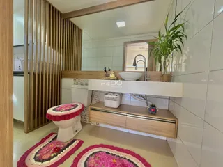 Foto de um banheiro com revestimento branco e detalhes em madeira.